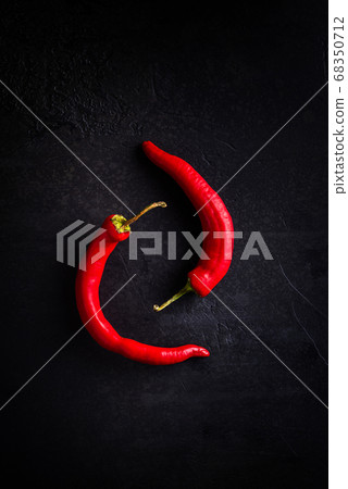 Two red chilli peppers on black background 68350712