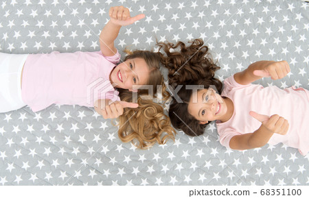 Kids show thumbs up gesture. Girls children on bed 68351100