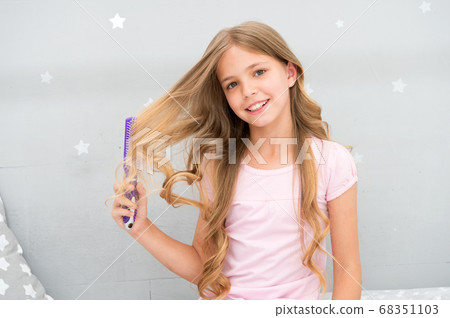 Child curly hairstyle hold hairbrush or comb. Comb 68351103
