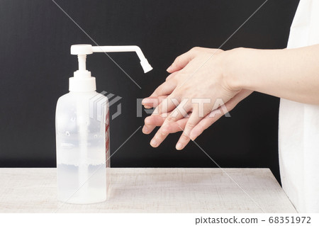 Women's hand to disinfect with alcohol Women's hand to disinfect with alcohol 68351972