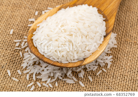 Pile of jasmin rice in a wooden spoon. 68352769