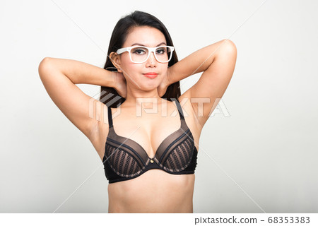 Portrait of Asian woman wearing lingerie against white background Portrait of Asian woman wearing lingerie against white background 68353383