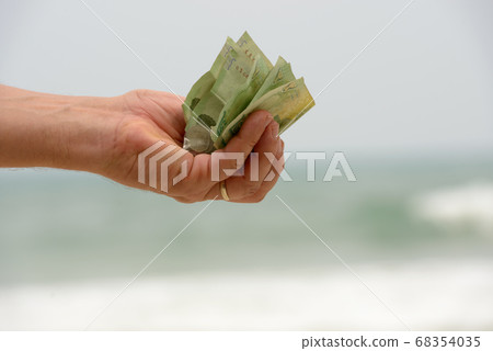 Portrait of hand holding 20 baht banknotes as Thai money Portrait of hand holding 20 baht banknotes as Thai money 68354035