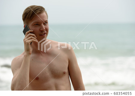 Young handsome shirtless tourist man relaxing at the beach 68354055