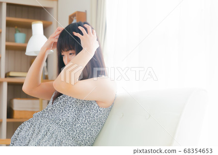 Pregnant woman holding her head Itchy scalp and scalp massage 68354653