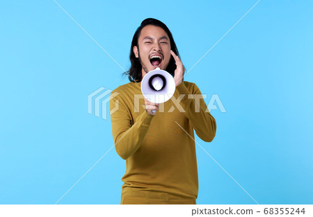 Young Asian man shouting into megaphone  68355244