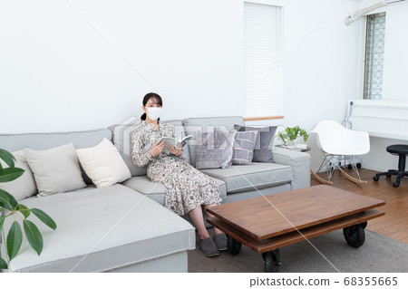 Woman wearing a mask and reading a book Woman wearing a mask and reading a book 68355665