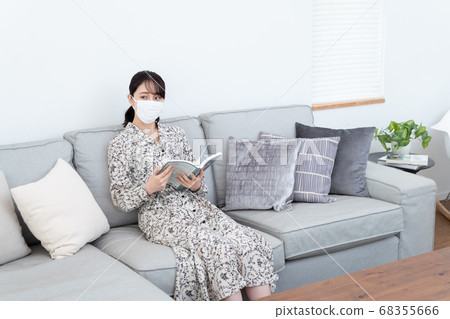 Woman wearing a mask and reading a book Woman wearing a mask and reading a book 68355666