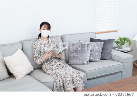 Woman wearing a mask and reading a book Woman wearing a mask and reading a book 68355667