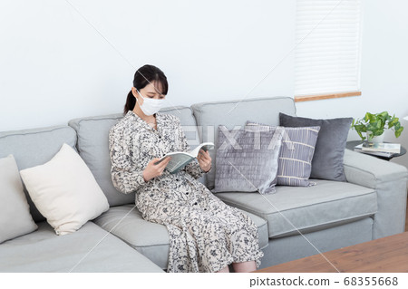 女人戴著口罩和看書 女人戴著口罩和看書 68355668