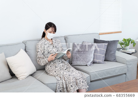 Woman wearing a mask and reading a book Woman wearing a mask and reading a book 68355669