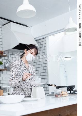 女人戴著口罩和烹飪 68355960