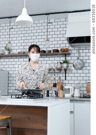 Woman wearing a mask and cooking Woman wearing a mask and cooking 68356016