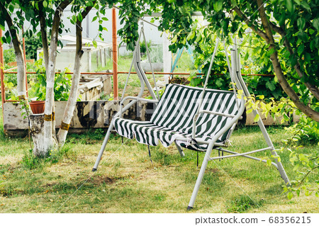 Swing among trees in backyard. Cottagecore and Swing among trees in backyard. Cottagecore and 68356215