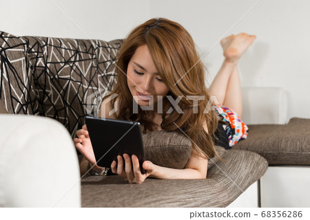 Happy young beautiful Asian woman in the living room at home Happy young beautiful Asian woman in the living room at home 68356286