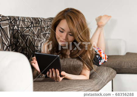 Young beautiful Asian woman in the living room at home Young beautiful Asian woman in the living room at home 68356288