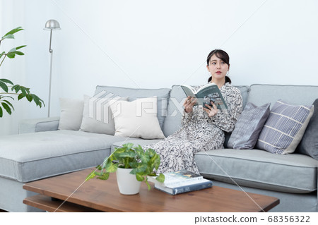 A woman reading a book on the sofa A woman reading a book on the sofa 68356322