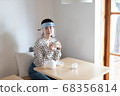 女人戴著口罩和喝茶 68356814