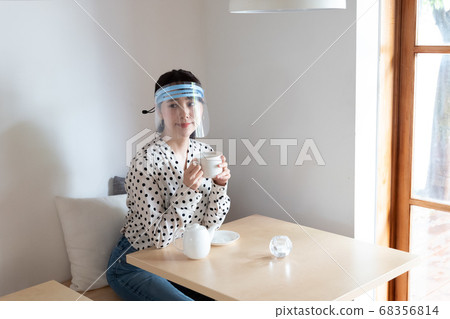 女人戴著口罩和喝茶 女人戴著口罩和喝茶 68356814