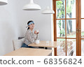 女人戴著口罩和喝茶 68356824