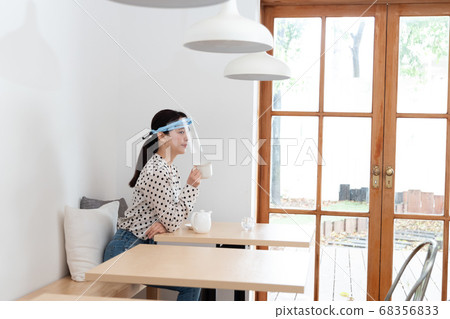 女人戴著口罩和喝茶 68356833