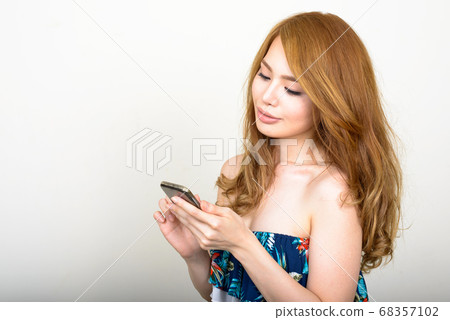 Portrait of young beautiful Asian woman using phone 68357102
