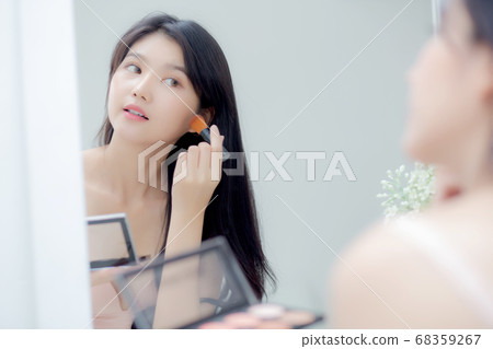 Beauty young asian woman happy and smile with face looking mirror applying makeup with brusher. Beauty young asian woman happy and smile with face looking mirror applying makeup with brusher. 68359267