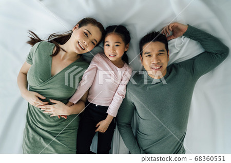 Portrait of cheerful Asian family lying down 68360551
