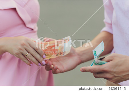 cropped shot of man giving russian rubles banknotes to woman. 68361243