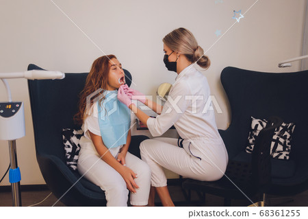 Close-up portrait of a female patient visiting dentist for teeth whitening in clinic,Teeth whitening procedure. 68361255
