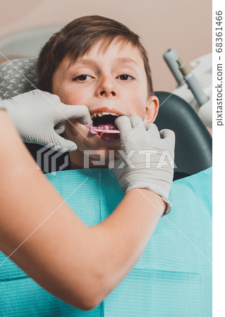 Boy in dentist chair with dental impression tray in her mouth Boy in dentist chair with dental impression tray in her mouth 68361466