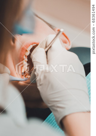 The boy examined by an orthodontist, he opened his mouth wide and the dentist examined his teeth. 68361494