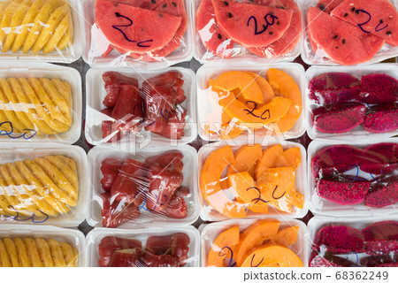 Chopped fruits (pineapple, watermelon, syzygium, papaya, dragonfruit) on plastic plates with the price 20 000 dongs (0.9 USD) on a stall at Ben Thanh market in Ho Chi Minh City, Vietnam. January 68362249