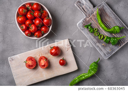 Fresh ripe tomatoes and hot chili peppers whole and sliced on old wooden cutting boards 68363045