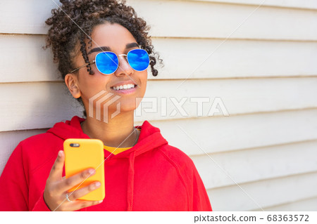 Girl teenager teen female young African American Wearing Blue Sunglasses With Cell Phone Girl teenager teen female young African American Wearing Blue Sunglasses With Cell Phone 68363572