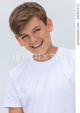 Boy teenager teen male child smiling happy wearing a white t-shirt Boy teenager teen male child smiling happy wearing a white t-shirt 68363573