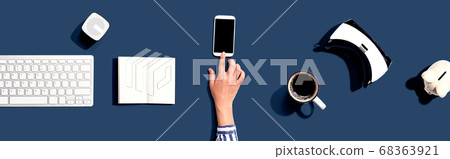 Person using a smartphone with other digital devices Person using a smartphone with other digital devices 68363921