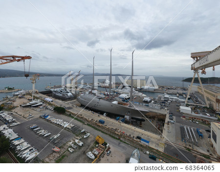 Aerial view of dry dock in La Ciotat city, France, the cargo crane, boats on repair, a luxury sail yacht and motor yacht in dry dock, mountain is on background 68364065