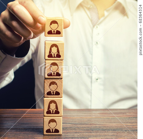 Business leader builds a people block tower. Definition of people in a hierarchical system. Meritocracy. Company organization. Hiring, recruiting workers. Leadership skills, team personnel management. 68364314