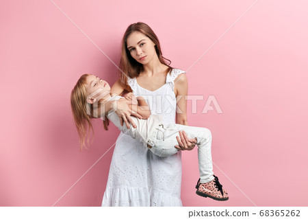 beautiful woman in dress holding her daughet with closed eyes beautiful woman in dress holding her daughet with closed eyes 68365262