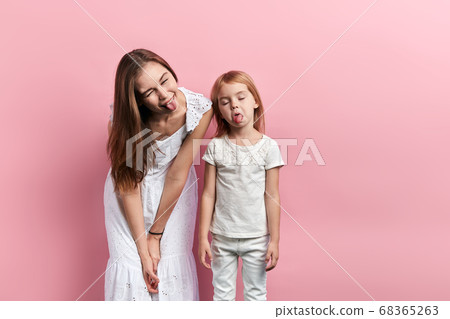 crazy woman and little girl with closed eyes making faces 68365263