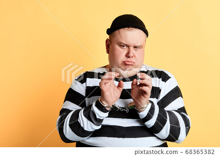 frowning sad unhappy fat man in striped clothes looking at the camera frowning sad unhappy fat man in striped clothes looking at the camera 68365382