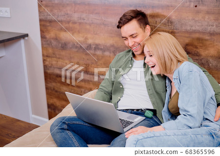 married couple lying on bed watching film married couple lying on bed watching film 68365596