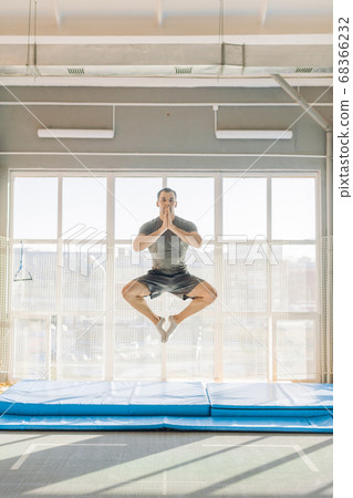 active sportsman performs lotus posture 68366232