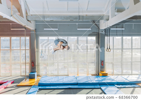 flexible guy doing flip over the mat 68366700