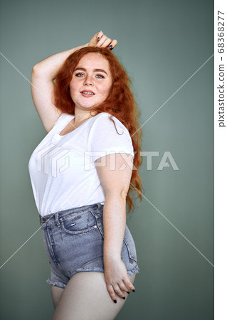 Funny smiling plus size young redhaired girl posing studio Funny smiling plus size young redhaired girl posing studio 68368277