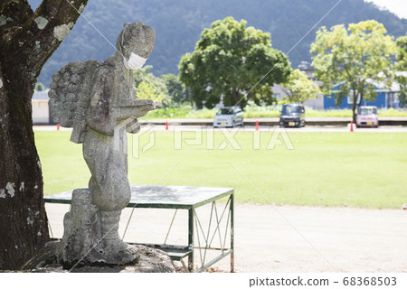 A stone statue of Kinjiro Ninomiya wearing a mask 68368503