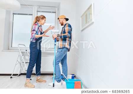 Couple has different points of view about home repair but try to make joke of it Couple has different points of view about home repair but try to make joke of it 68369265