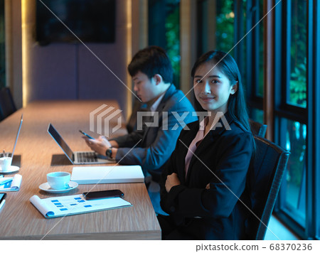 Portrait of businesswoman sitting with her Portrait of businesswoman sitting with her 68370236