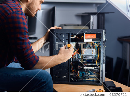 specialised computer repair technician testing an old system unit 68370721